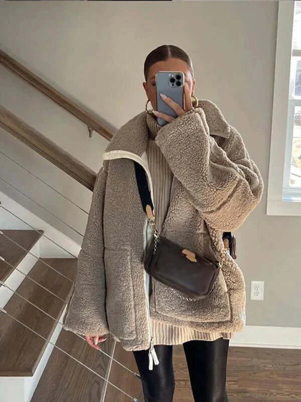 Damen Teddyjacke beige oversize mit schwarzer Hose und Umhängetasche indoor