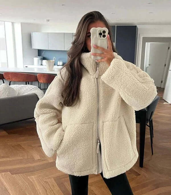 Damen Teddyjacke beige oversize mit schwarzer Hose und Umhängetasche indoor
